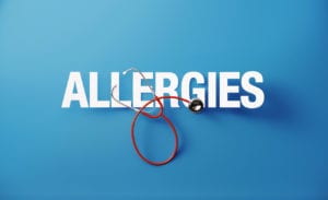 Red stethoscope and allergies text on blue background.