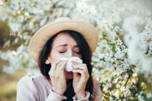 woman sneezing due to Pollen Allergy