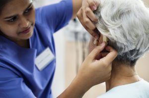 Hearing loss specialist helping woman