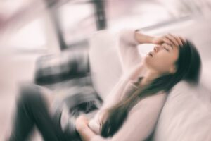 Sick woman with headache feeling faint vertigo holding head