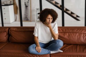 african american girl touches throat from laryngitis pain
