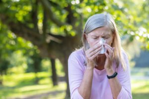 gray-haired woman suffering from seasonal allergies