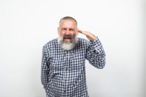 Mature man suffering from hearing loss in one ear.