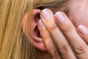 Woman lays finger on the ear caused by ear ache.